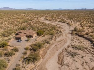 Aerial view of a desert property near a dry wash that can carry flash flood runoff during heavy storms.